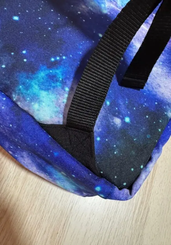 Detalle de la base reforzada de la mochila personalizable con estampado espacial