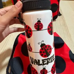 Botella de aluminio personalizada con diseño de mariquitas rojas y nombre Valerie.
