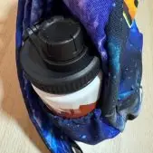 Botella de aluminio personalizada guardada en el bolsillo lateral de una mochila personalizada