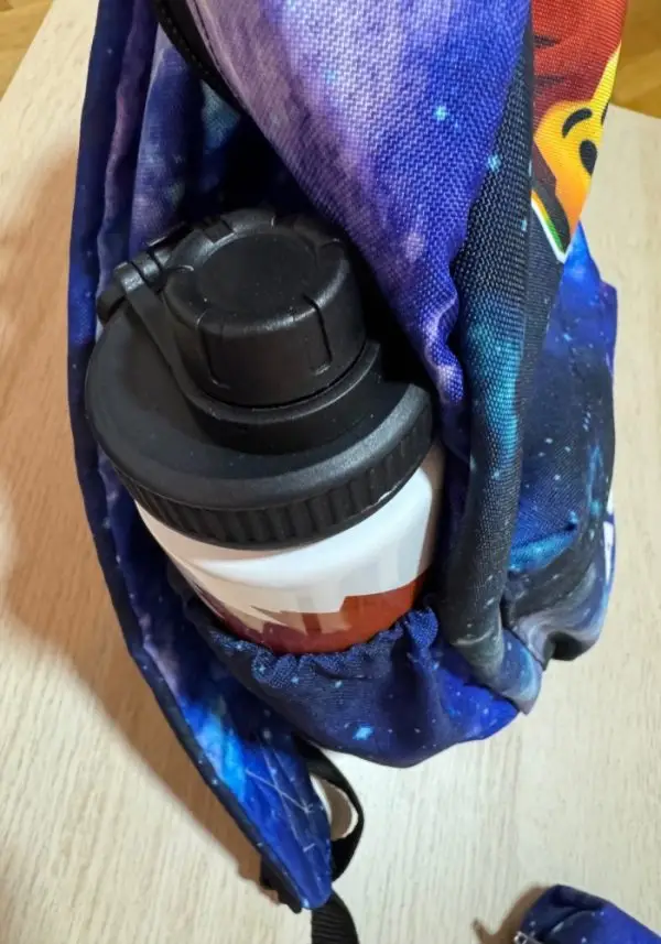 Botella de aluminio personalizada guardada en el bolsillo lateral de una mochila personalizada